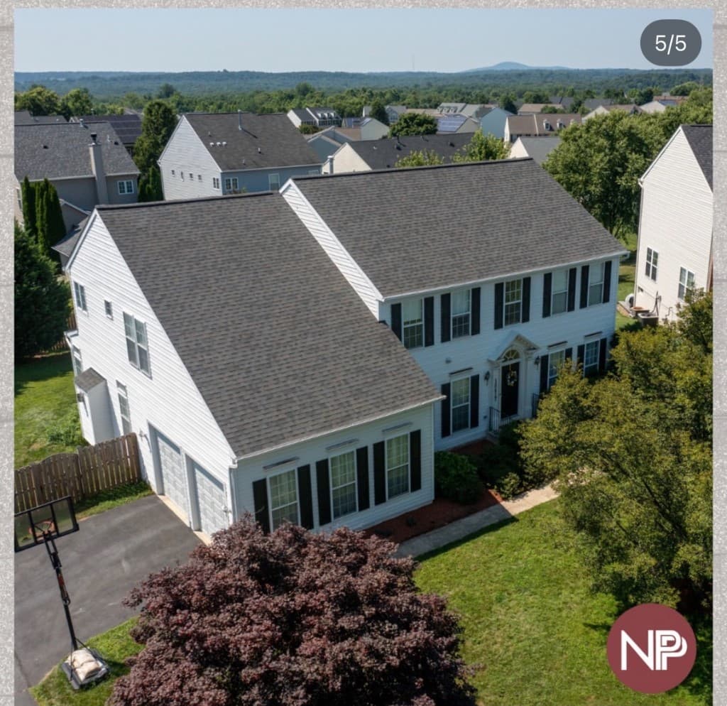 Aerial view of a completed New Paradigm Projects residential roof in a Maryland neighborhood
